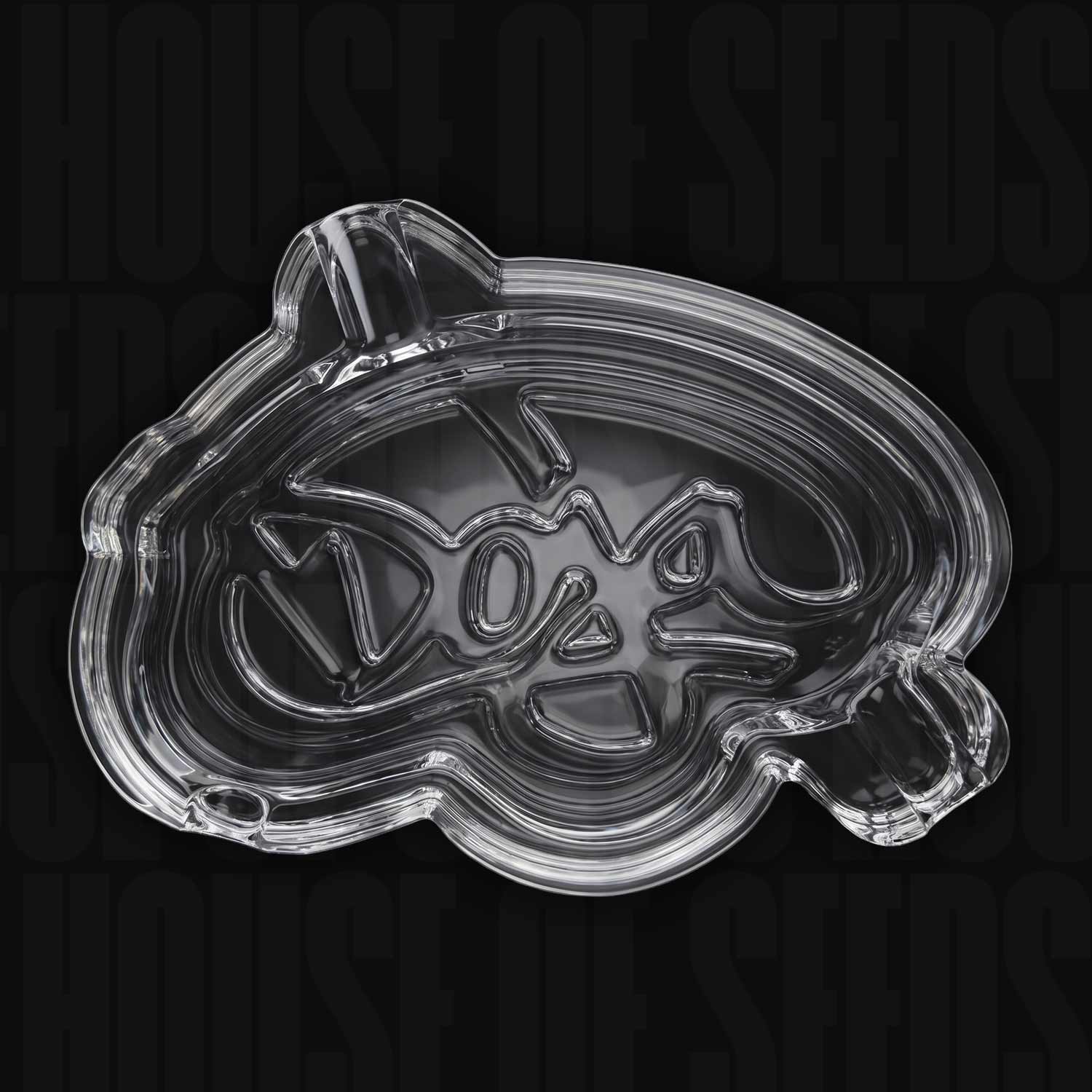 Doja Aschenbecher (Glas): Klares Glas-Tablett in Form eines Samens mit der Aufschrift „Doja“ im Inneren. Marke: Doja.